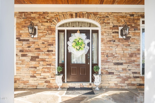 view of exterior entry featuring stone siding and brick siding