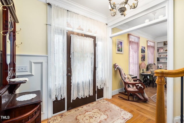 foyer entrance with crown molding and wood finished floors