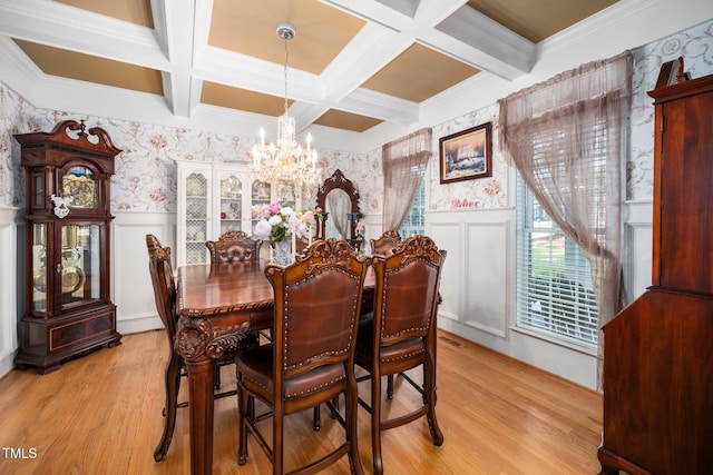 dining space with wallpapered walls, a wainscoted wall, light wood-style flooring, a chandelier, and beam ceiling