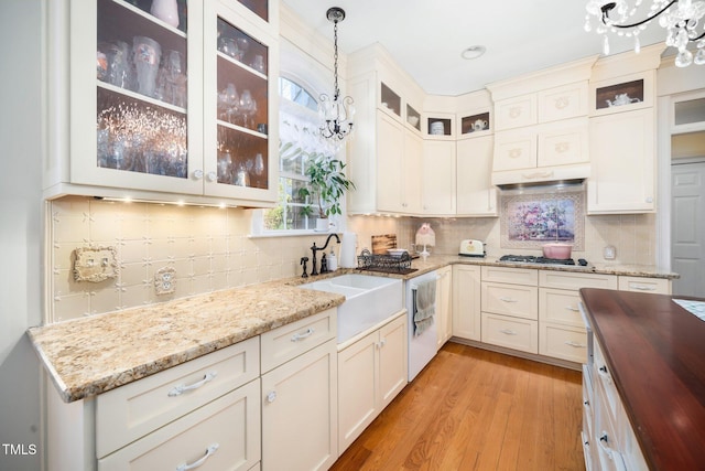 kitchen featuring light wood-style flooring, stainless steel gas cooktop, a sink, wooden counters, and hanging light fixtures