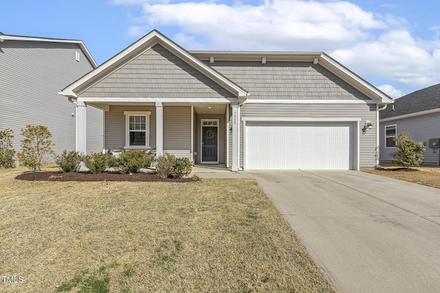 view of front of house featuring a garage, a front yard, covered porch, and driveway