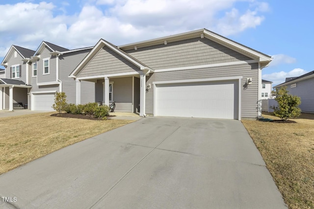 view of front of home featuring driveway, a front lawn, and an attached garage