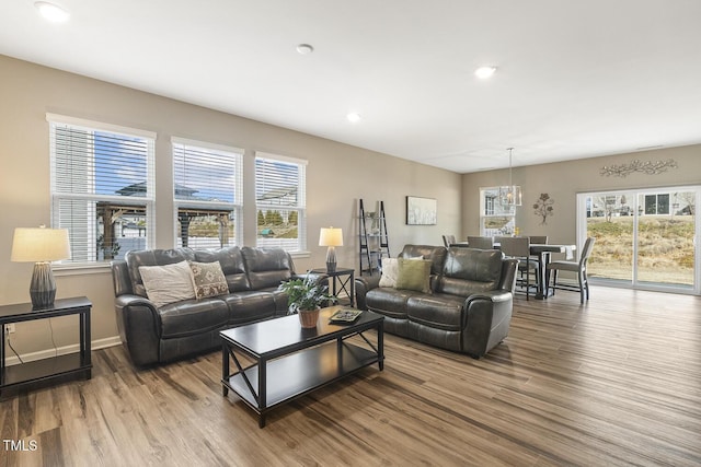 living area featuring an inviting chandelier, plenty of natural light, wood finished floors, and recessed lighting