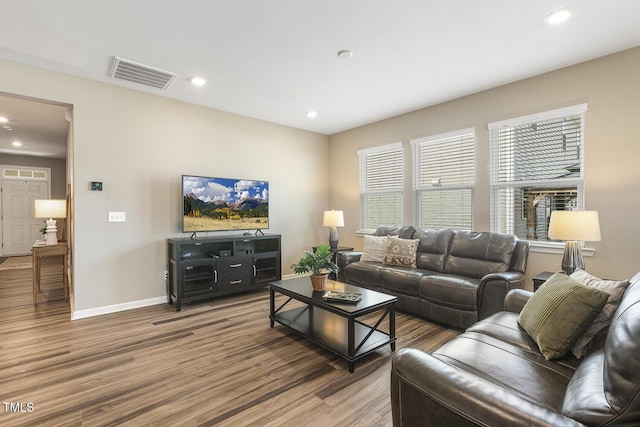 living area featuring baseboards, visible vents, wood finished floors, and recessed lighting