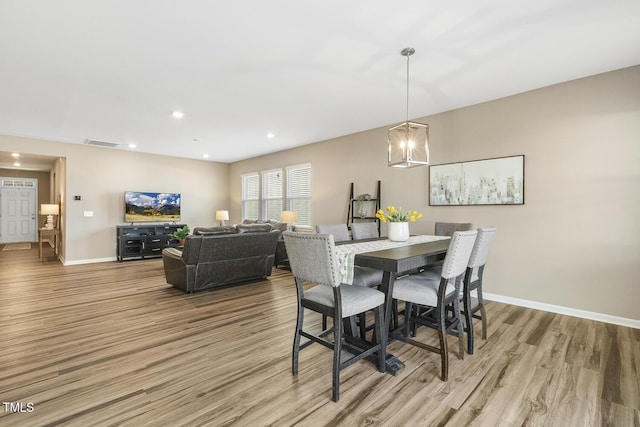 dining room with visible vents, baseboards, wood finished floors, a notable chandelier, and recessed lighting