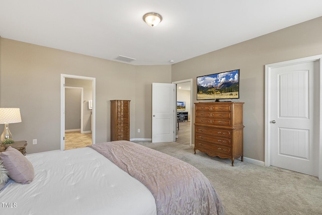 bedroom with baseboards, visible vents, connected bathroom, and light colored carpet