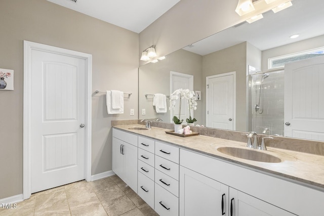 full bathroom with baseboards, double vanity, a sink, and a shower stall