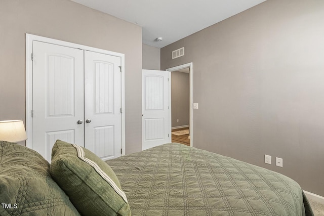 bedroom with a closet, visible vents, and baseboards