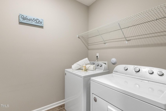 laundry area with wood finished floors, laundry area, baseboards, and separate washer and dryer