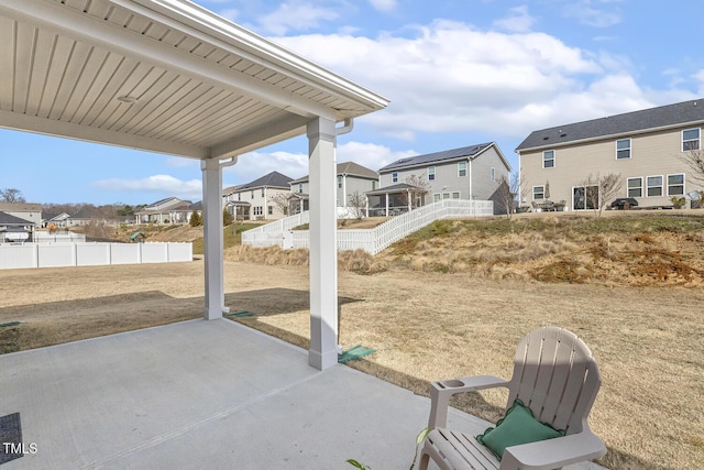 view of patio featuring fence and a residential view