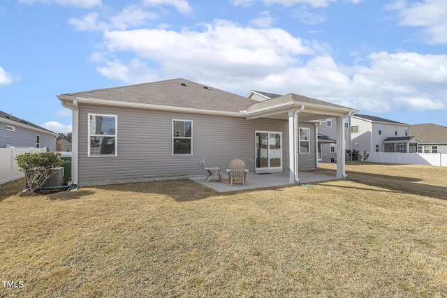 back of property with roof with shingles, a lawn, a patio area, and fence