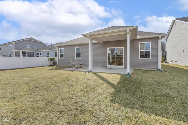 rear view of property featuring a lawn, a patio area, and fence