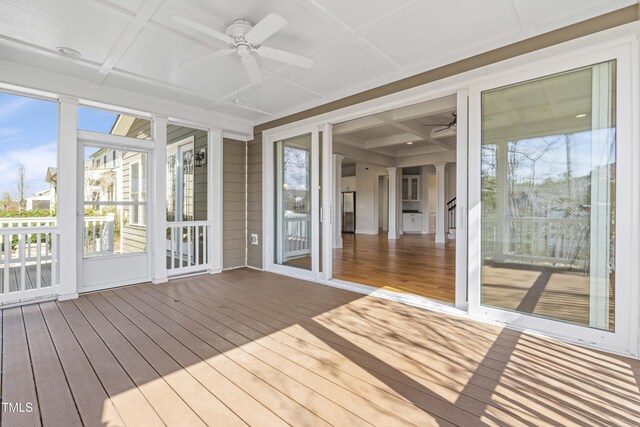 unfurnished sunroom featuring beam ceiling, coffered ceiling, and a ceiling fan