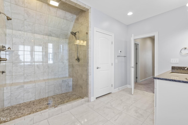 full bath with vanity, baseboards, and walk in shower