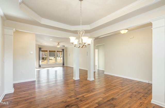 unfurnished dining area with dark wood-style floors, a tray ceiling, and baseboards