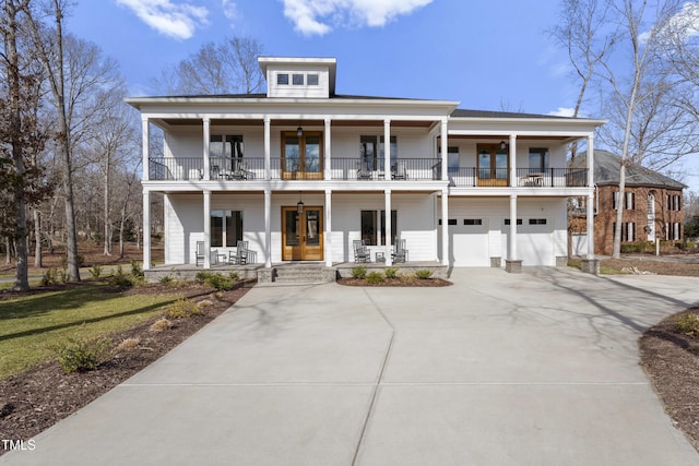 view of front of house with french doors, a balcony, a garage, and covered porch