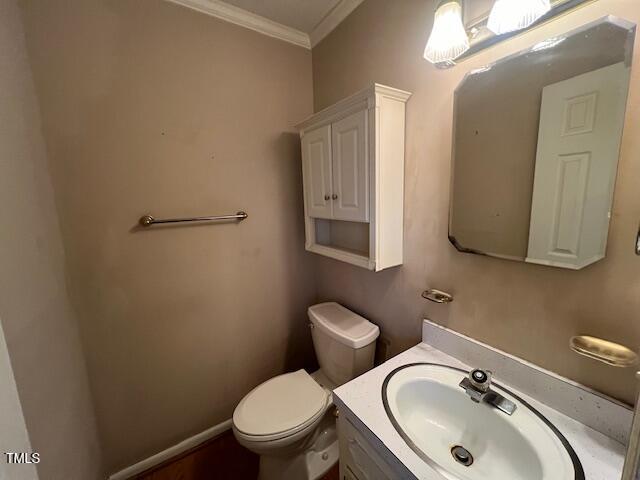 bathroom with vanity, crown molding, and toilet