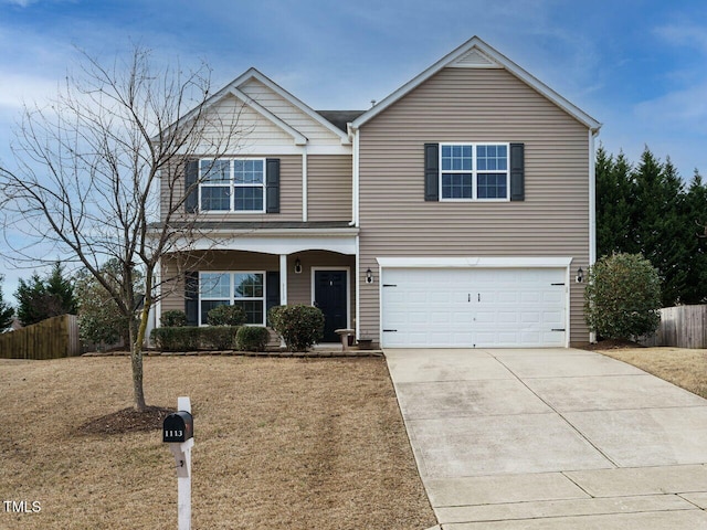 traditional home featuring a front lawn, concrete driveway, fence, and an attached garage