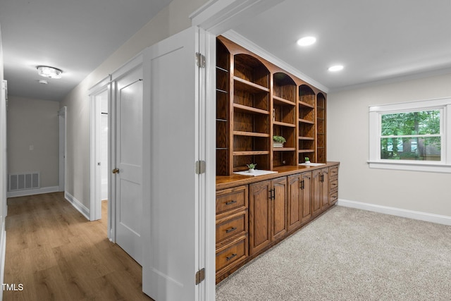 hall featuring recessed lighting, visible vents, ornamental molding, light carpet, and baseboards