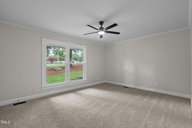 carpeted spare room with baseboards, visible vents, and crown molding