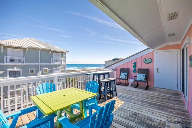 deck featuring visible vents, a water view, and a view of the beach