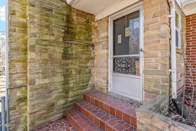 doorway to property with brick siding