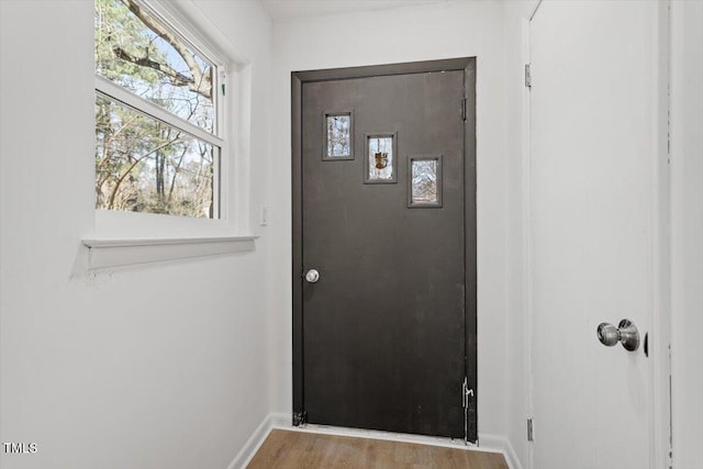 doorway to outside with baseboards and wood finished floors