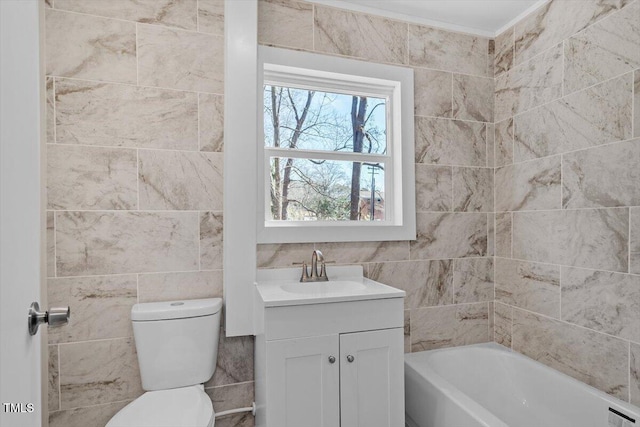 bathroom with vanity, a bathtub, toilet, and tile walls