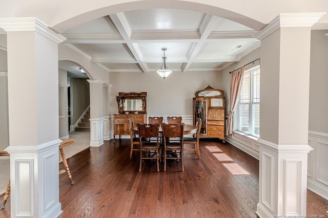 dining area with decorative columns, dark hardwood / wood-style floors, coffered ceiling, ornamental molding, and beamed ceiling