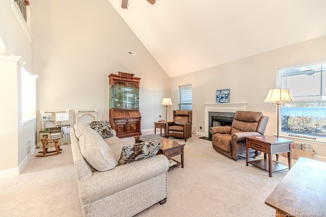 living room with ceiling fan, high vaulted ceiling, and light carpet