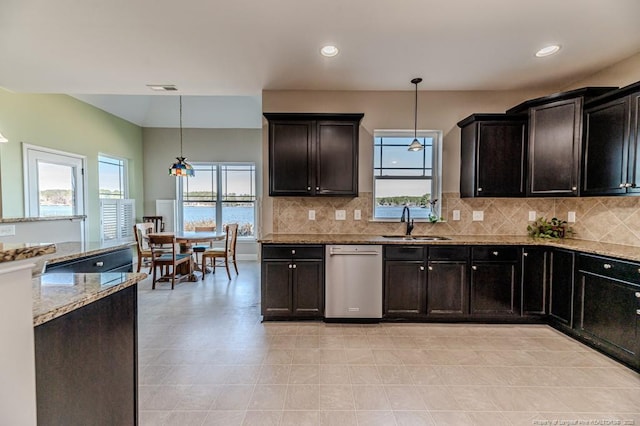 kitchen with decorative backsplash, dishwasher, sink, and hanging light fixtures