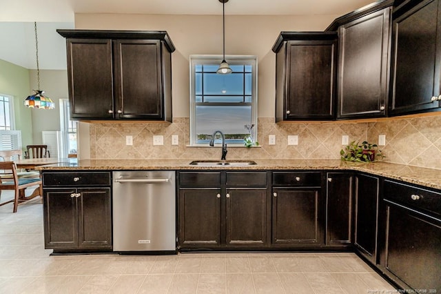 kitchen featuring light stone counters, dishwasher, sink, and hanging light fixtures