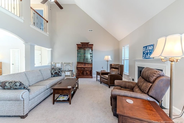 living room featuring ceiling fan, light colored carpet, lofted ceiling, and decorative columns