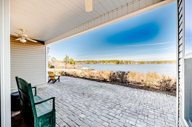 view of patio / terrace featuring a water view and ceiling fan