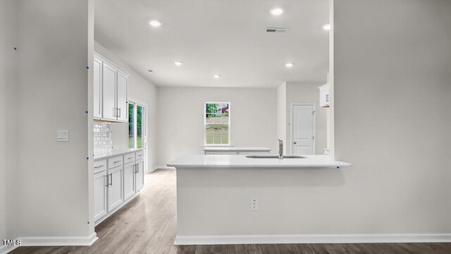 1009 Ocean Ct, Carthage, NC 28327 - kitchen with white cabinets, light countertops, wood finished floors, recessed lighting, and a peninsula
