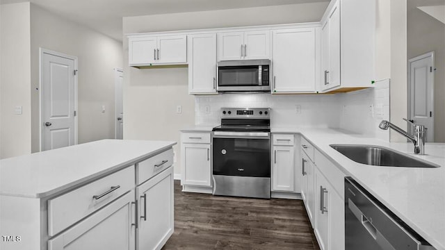 1009 Ocean Ct, Carthage, NC 28327 - kitchen featuring appliances with stainless steel finishes, dark wood finished floors, tasteful backsplash, and white cabinetry