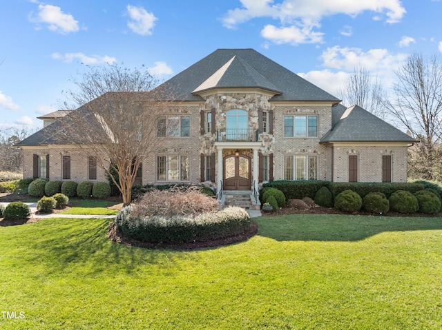 french country style house featuring french doors, a front yard, and brick siding