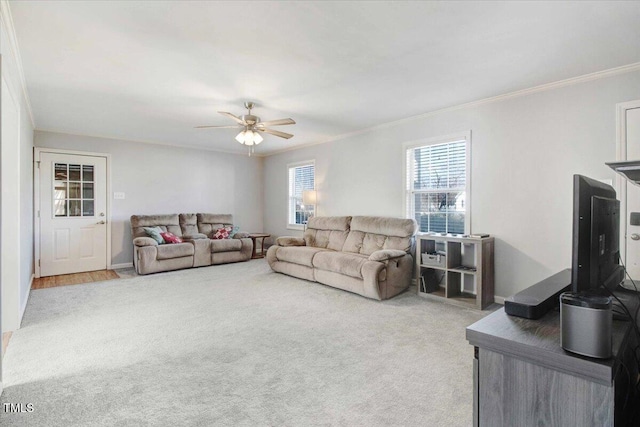 living room featuring carpet floors, ornamental molding, and ceiling fan