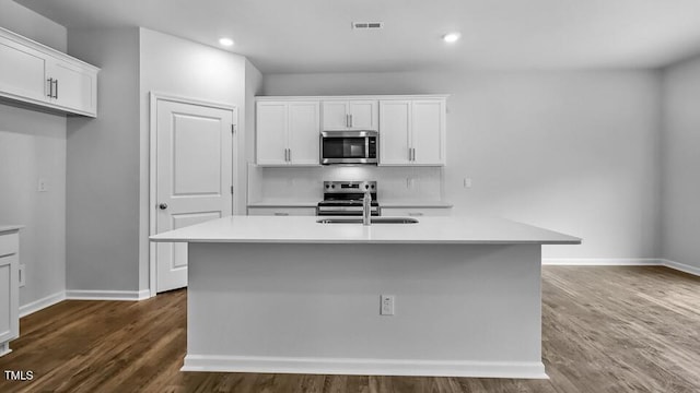 989 Ocean Ct, Carthage, NC 28327 - kitchen with stainless steel appliances, white cabinetry, dark wood-style floors, light countertops, and recessed lighting
