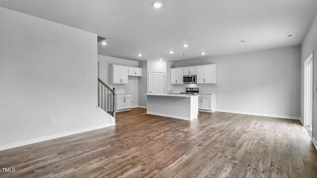 989 Ocean Ct, Carthage, NC 28327 - unfurnished living room with wood finished floors, recessed lighting, and stairway
