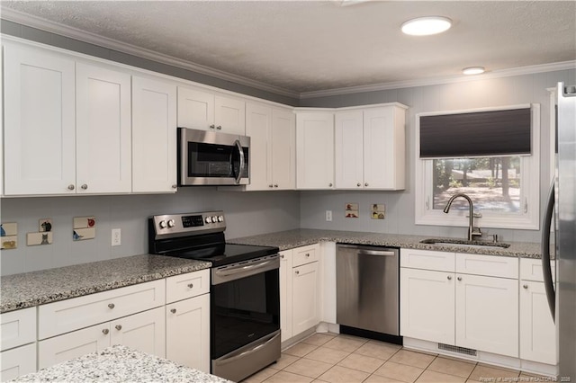 kitchen with crown molding, a sink, white cabinets, and stainless steel appliances