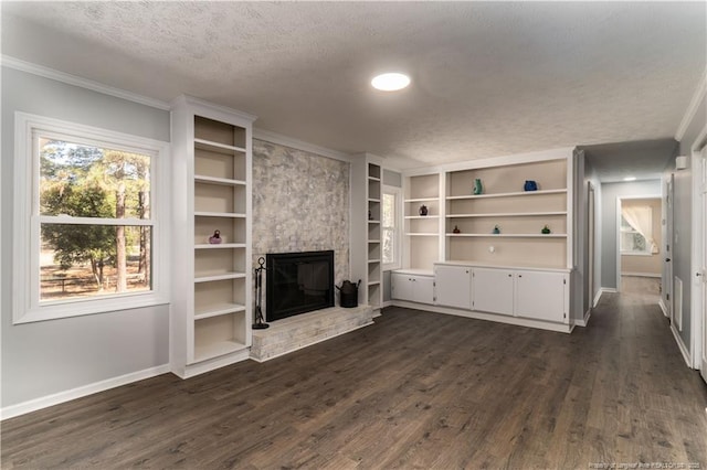 unfurnished living room featuring a textured ceiling, dark wood finished floors, a large fireplace, baseboards, and ornamental molding