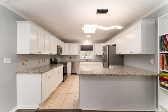 kitchen featuring a peninsula, light stone countertops, white cabinets, a sink, and stainless steel appliances