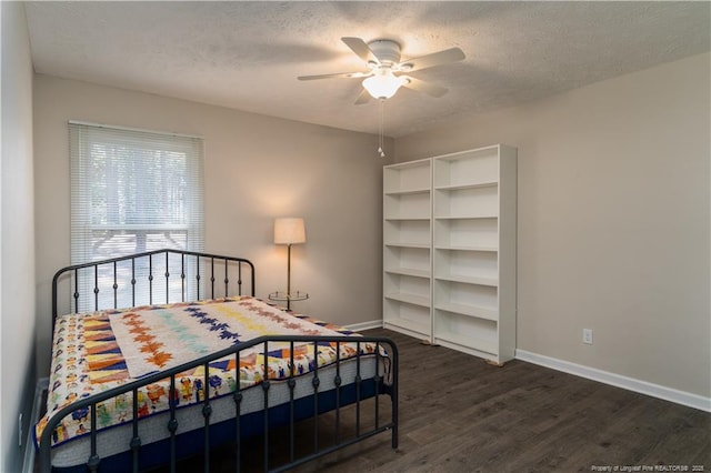 bedroom with baseboards, ceiling fan, dark wood-style flooring, and a textured ceiling