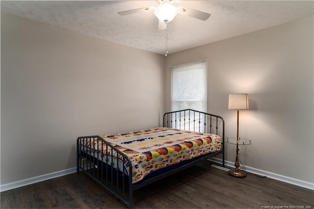 bedroom with baseboards, a textured ceiling, and wood finished floors