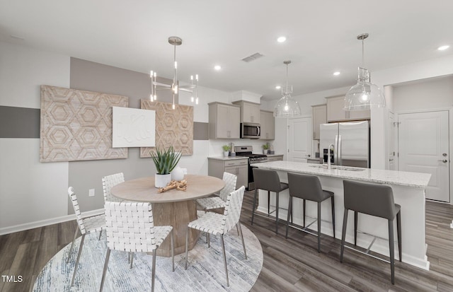 dining room featuring dark hardwood / wood-style floors, sink, and a notable chandelier