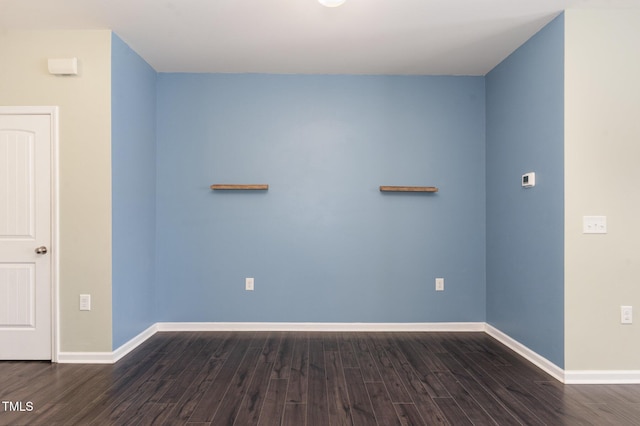 empty room with dark wood-style floors and baseboards