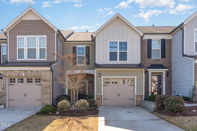 view of front facade with an attached garage, stone siding, board and batten siding, and concrete driveway