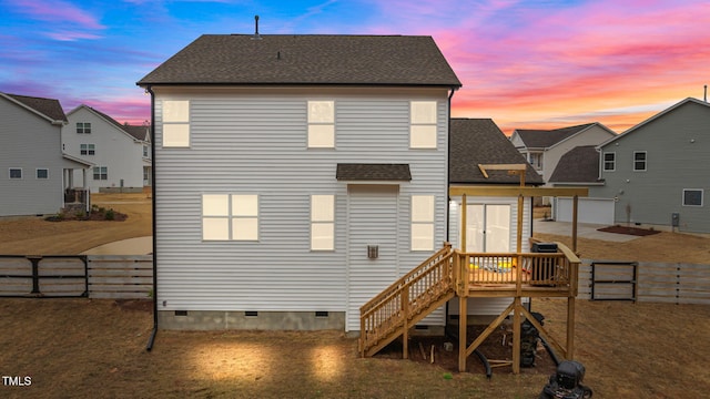 40 Long Needle Ct, Youngsville, NC 27596 - back of house at dusk with a fenced backyard, crawl space, a shingled roof, and a wooden deck