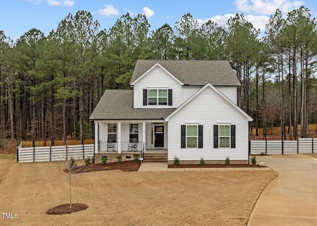 view of front facade featuring roof with shingles, a porch, and fence